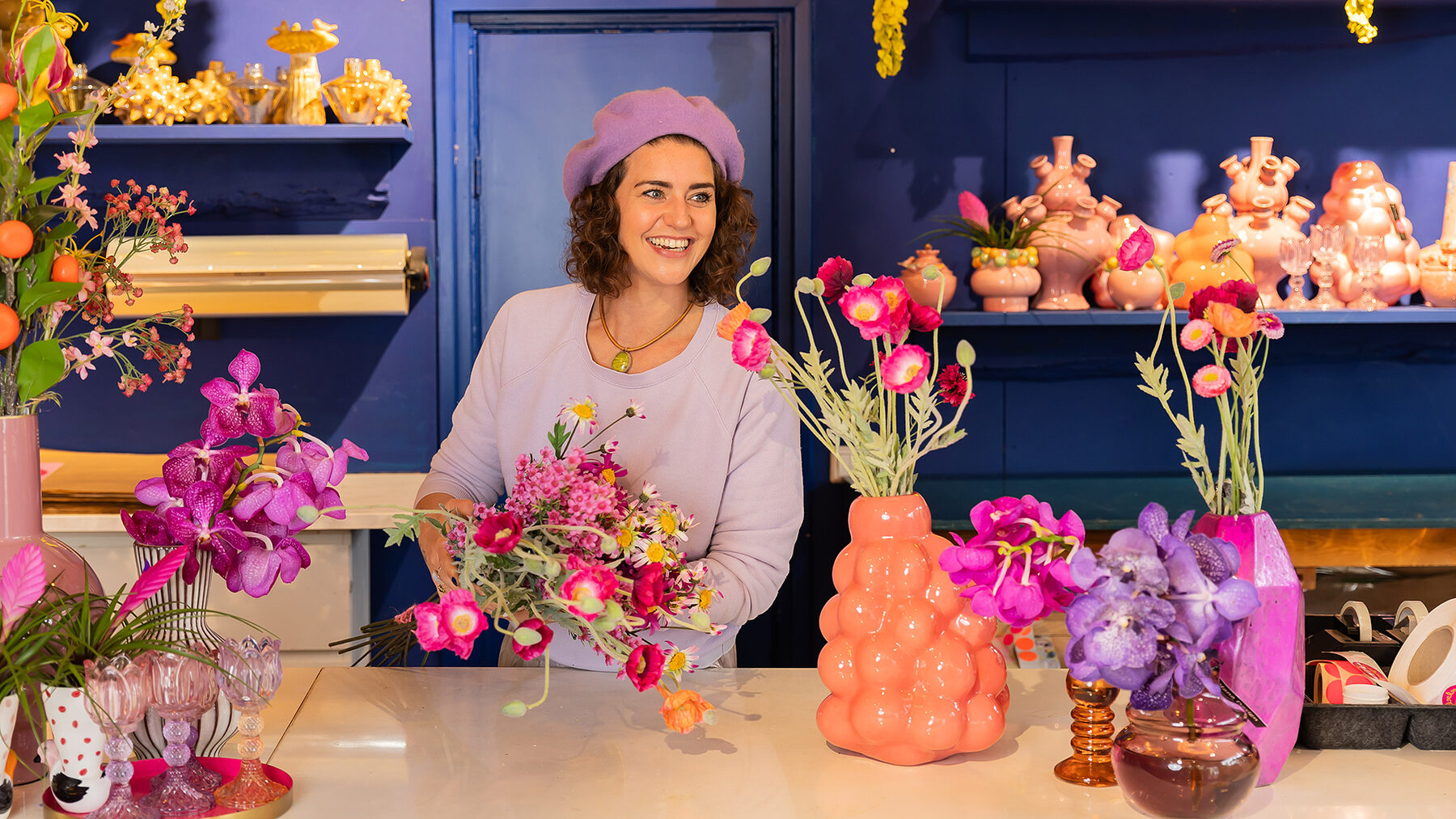Achter de toonbank bij Miss Bloem, tussen bloemen en kleurrijke vazen