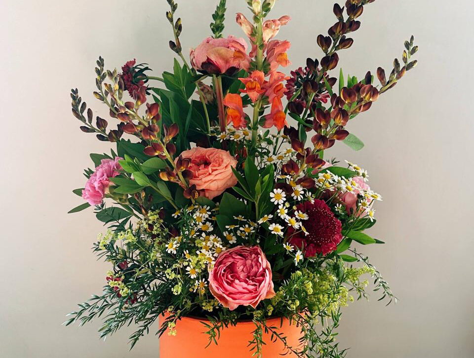 Rijk boeket met rozen in roze en oranje tinten