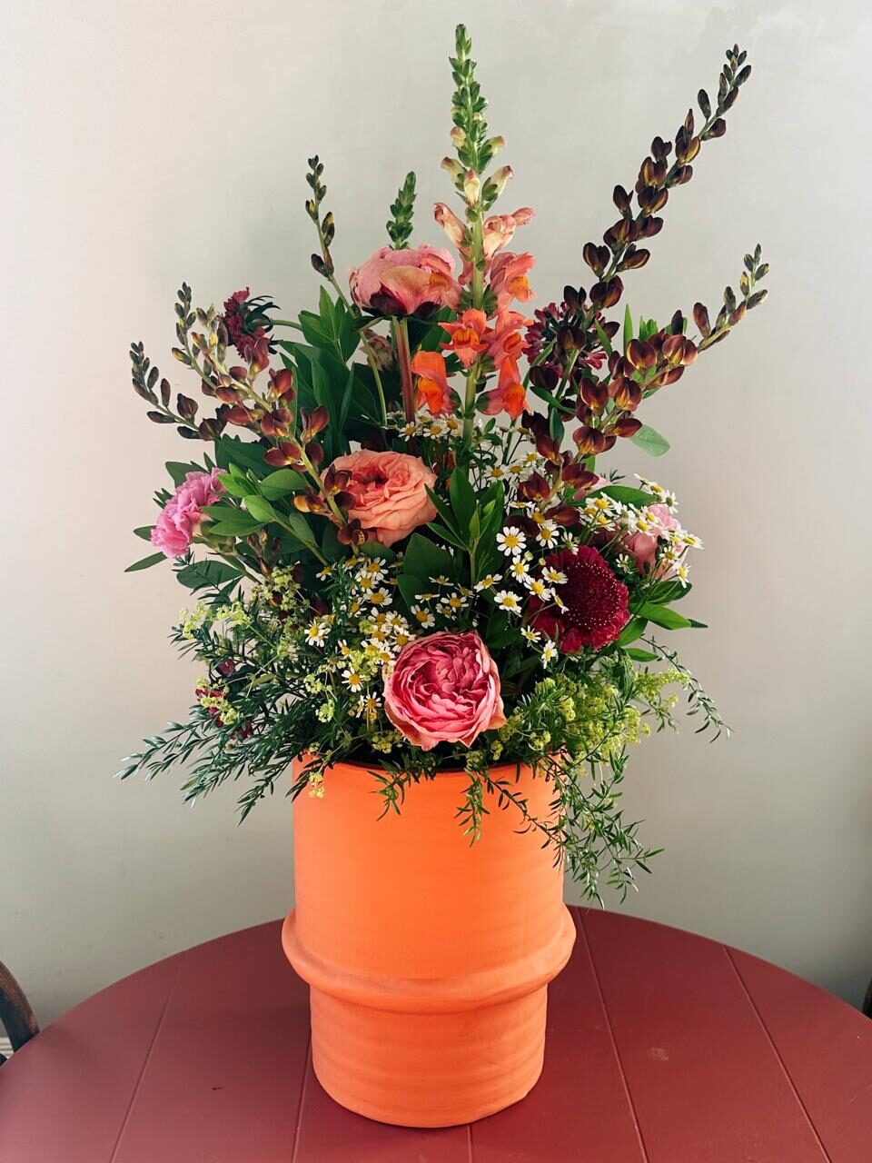 Bloemstuk in oranje vaas